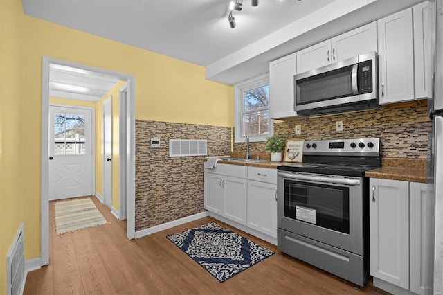 kitchen with white cabinets, appliances with stainless steel finishes, and plenty of natural light