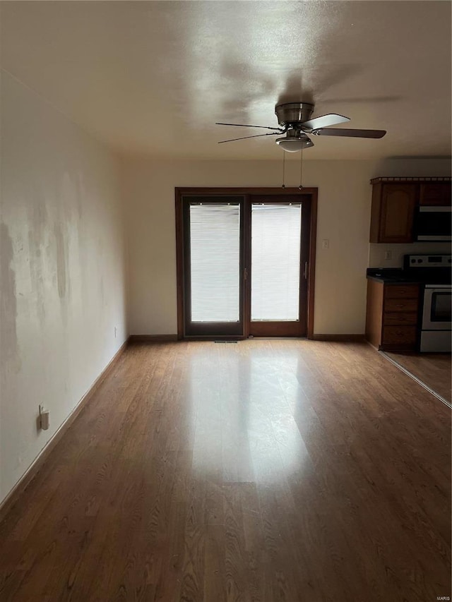 unfurnished living room with ceiling fan and light wood-type flooring