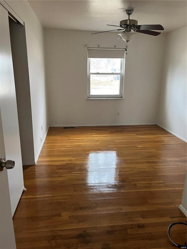 unfurnished room with dark hardwood / wood-style floors and ceiling fan