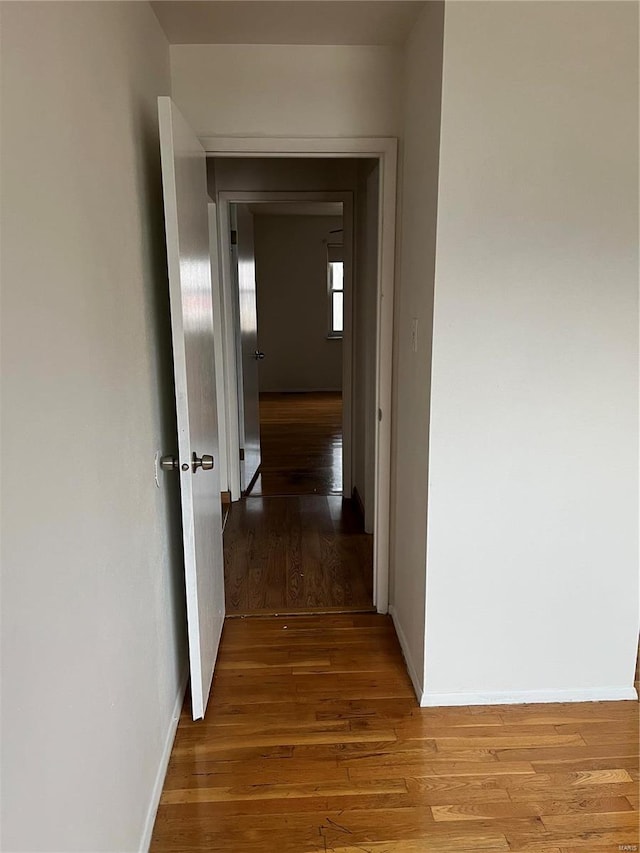 corridor with hardwood / wood-style flooring