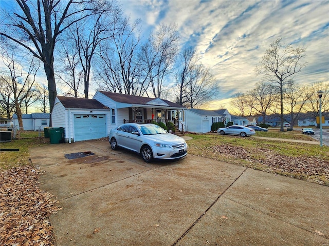 ranch-style house featuring a garage, concrete driveway, a porch, and a residential view