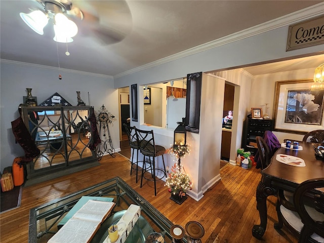 living room featuring baseboards, wood finished floors, and crown molding