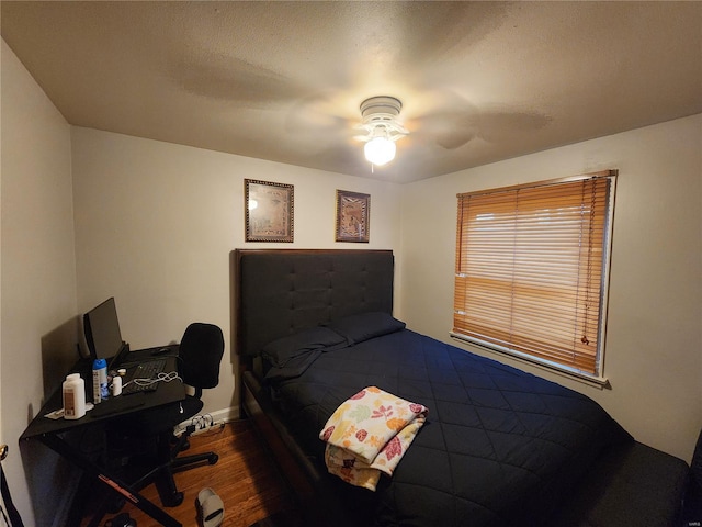 bedroom featuring a textured ceiling, dark hardwood / wood-style floors, and ceiling fan