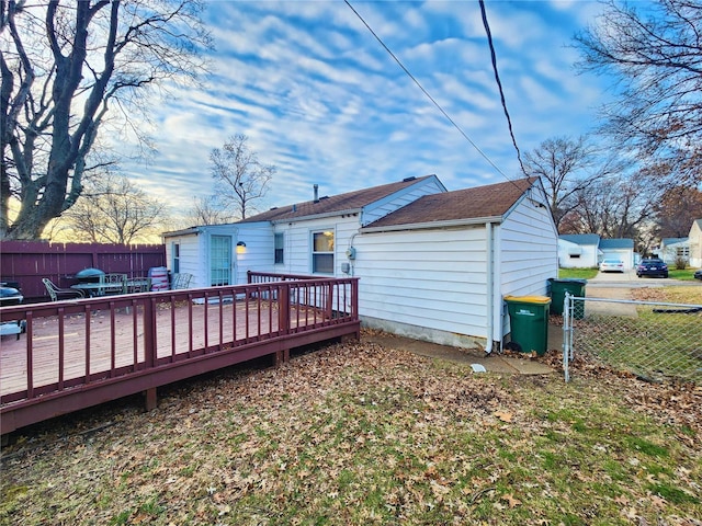 back of house with fence and a wooden deck