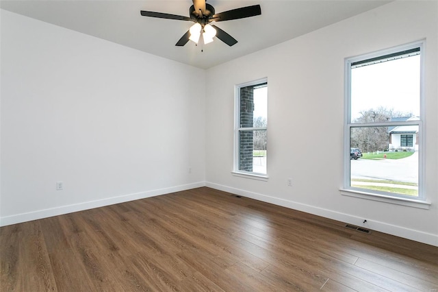 empty room featuring ceiling fan and dark hardwood / wood-style flooring