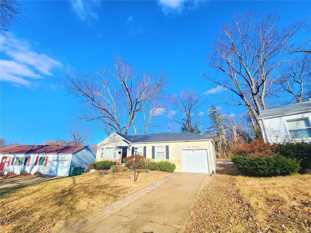 single story home featuring concrete driveway, a front lawn, and an attached garage