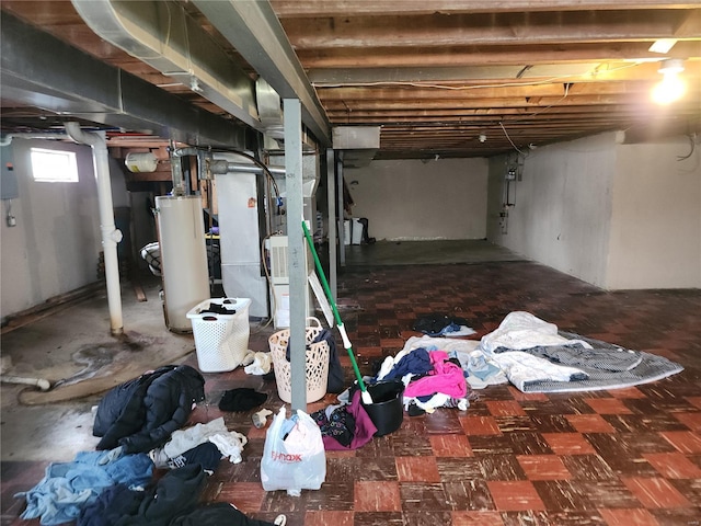 basement featuring electric panel and water heater