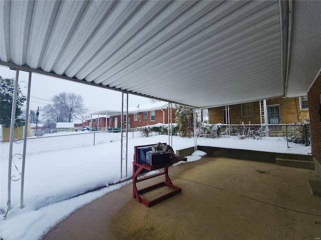 snow covered patio featuring fence
