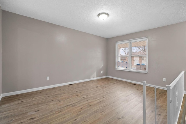 spare room with hardwood / wood-style floors and a textured ceiling