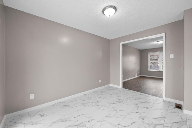 unfurnished room featuring a textured ceiling