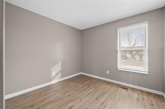 spare room with light hardwood / wood-style flooring