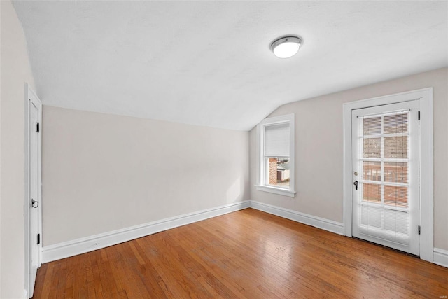 additional living space with wood-type flooring and lofted ceiling