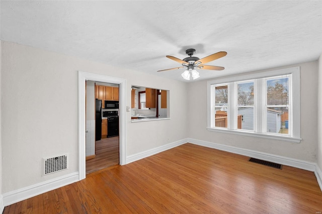 unfurnished room featuring hardwood / wood-style flooring, ceiling fan, and a textured ceiling