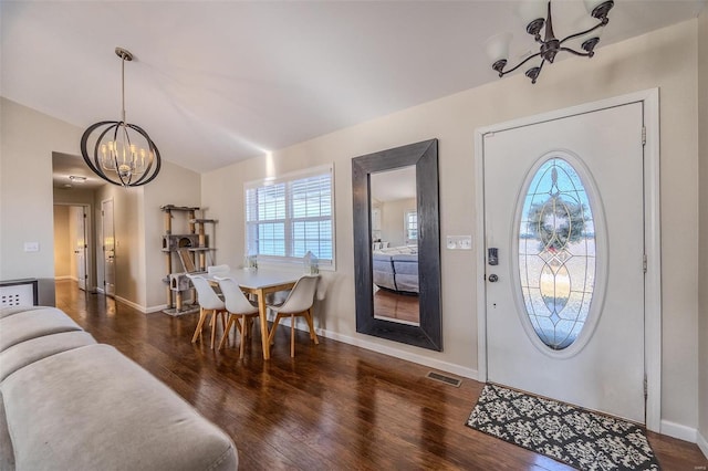 entrance foyer with dark hardwood / wood-style flooring and an inviting chandelier