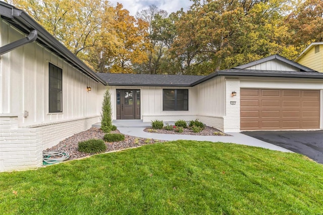 view of front of home with a front yard and a garage