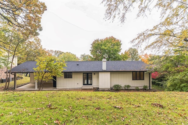 view of front of home with a patio area, french doors, and a front lawn