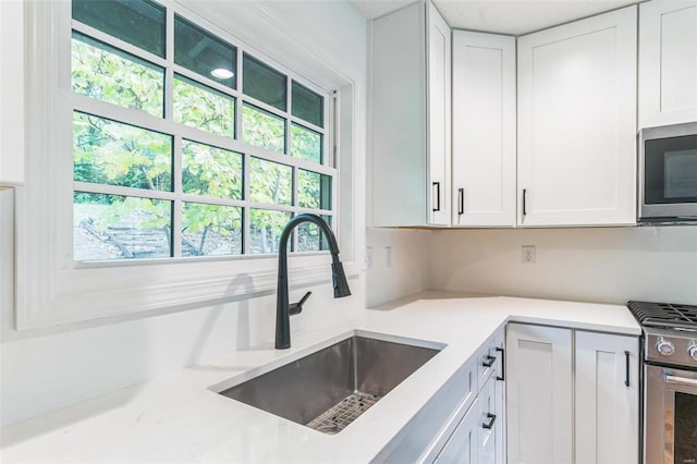 kitchen featuring white cabinetry, sink, and appliances with stainless steel finishes