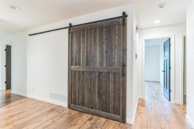 interior space featuring a barn door and light hardwood / wood-style flooring