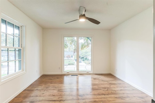 spare room with light wood-type flooring and ceiling fan