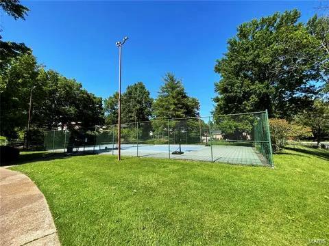 surrounding community with a yard and tennis court