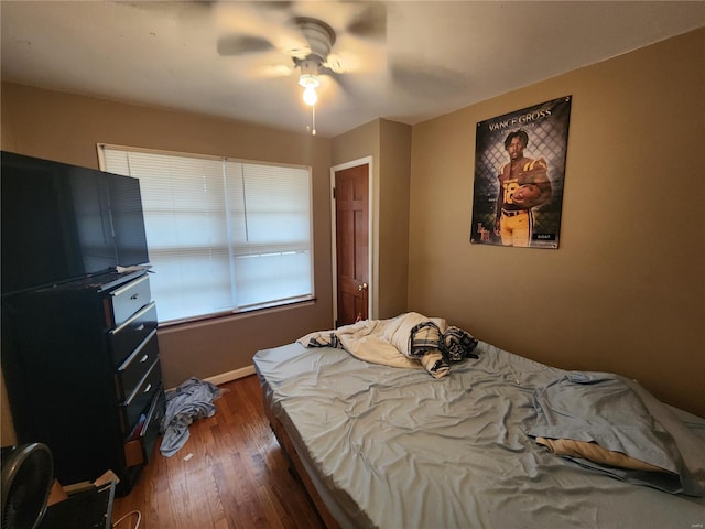 bedroom with dark hardwood / wood-style floors and ceiling fan