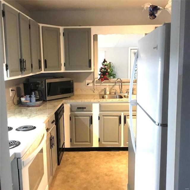 kitchen with gray cabinetry, sink, light colored carpet, and white appliances