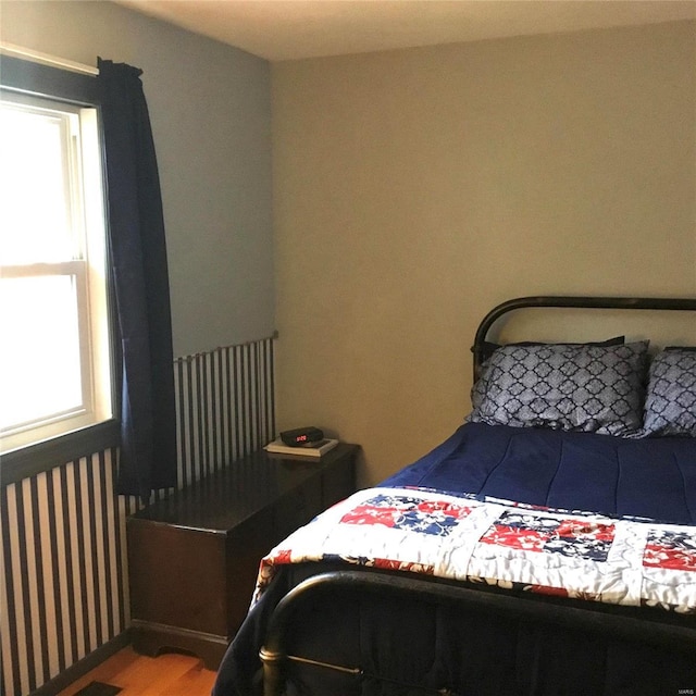 bedroom featuring hardwood / wood-style flooring and radiator