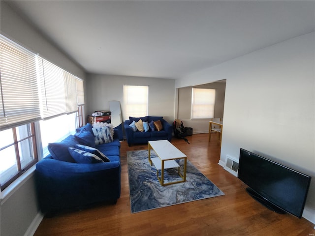 living area featuring visible vents, baseboards, and wood finished floors