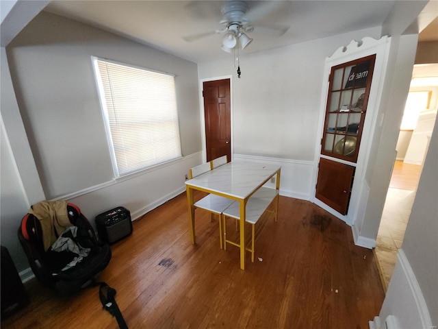 dining area with baseboards, a ceiling fan, and wood finished floors