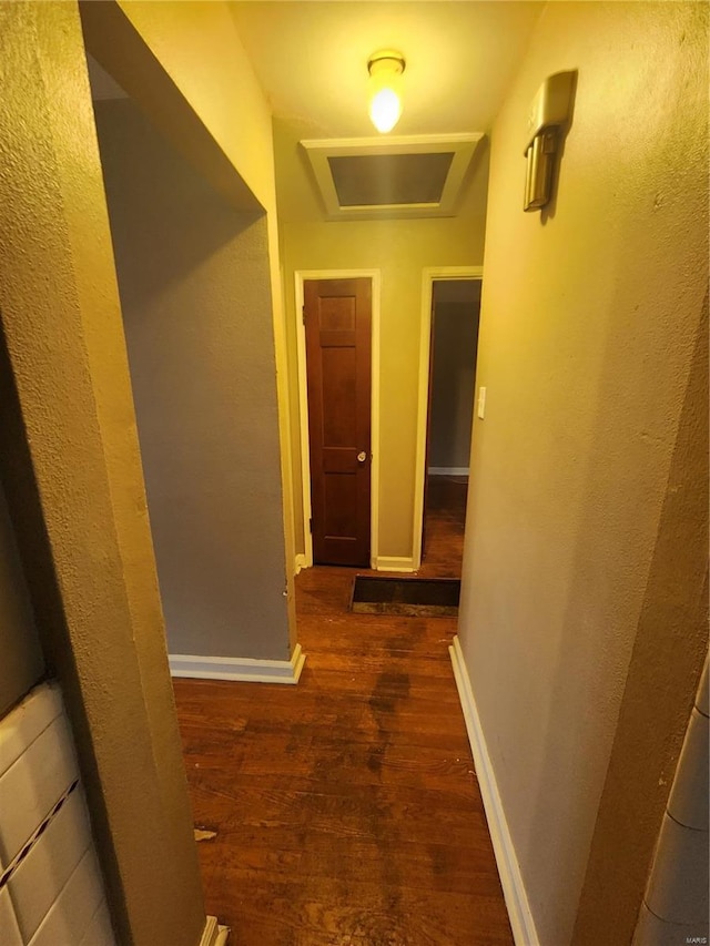 hallway with dark wood-style floors and baseboards