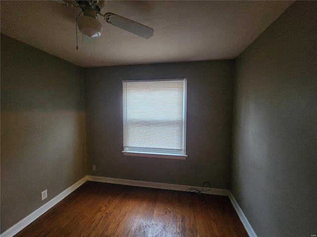 spare room featuring dark wood-type flooring and ceiling fan