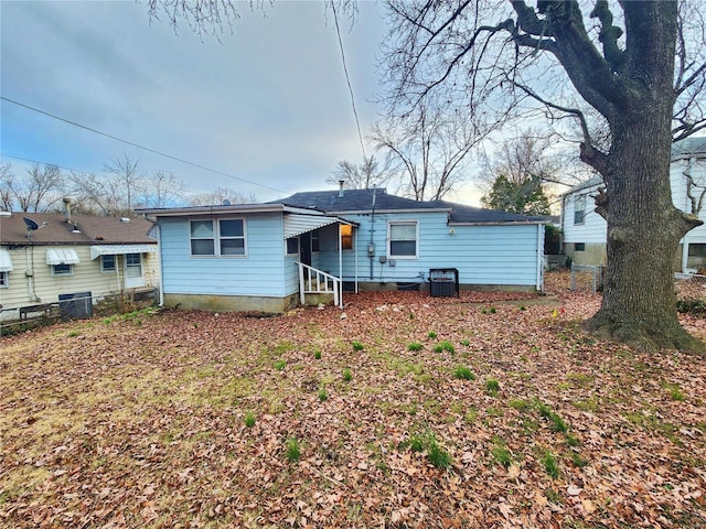 rear view of property with central air condition unit and fence