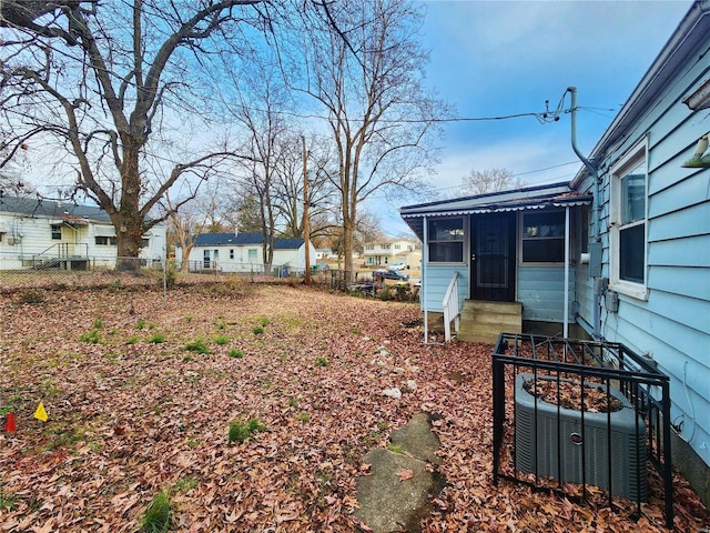 view of yard featuring entry steps, cooling unit, and fence