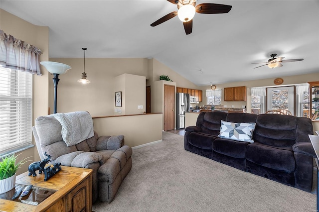 living area featuring lofted ceiling, carpet flooring, baseboards, and ceiling fan