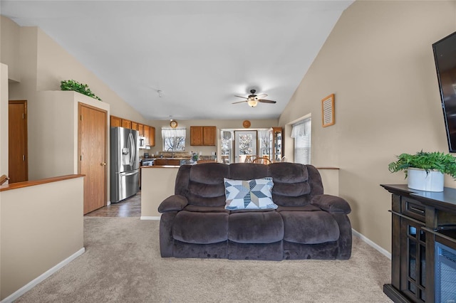 carpeted living room featuring a ceiling fan, baseboards, and high vaulted ceiling