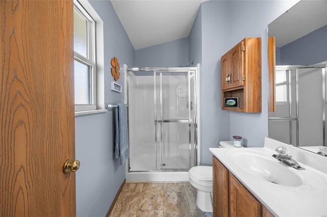 bathroom featuring a stall shower, toilet, vanity, and vaulted ceiling