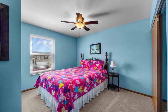 carpeted bedroom featuring baseboards and ceiling fan