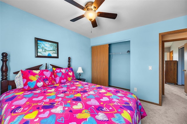 carpeted bedroom featuring a ceiling fan, baseboards, and a closet