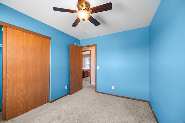 unfurnished bedroom with a closet, ceiling fan, baseboards, and carpet floors