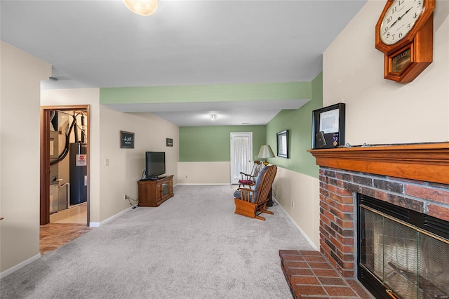 sitting room with a brick fireplace, electric water heater, baseboards, and carpet floors