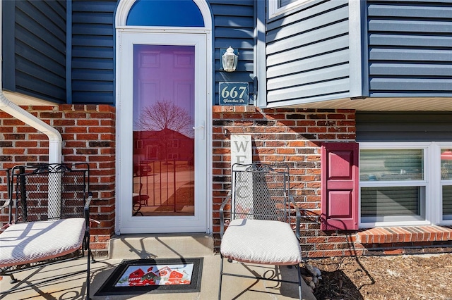 entrance to property featuring brick siding