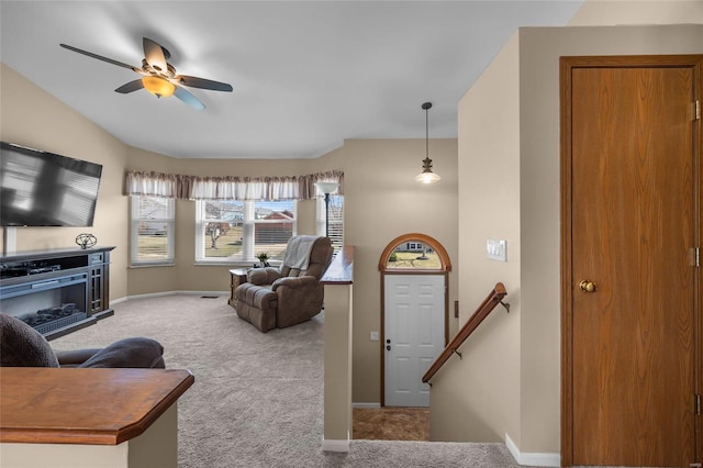 living area with carpet flooring, ceiling fan, and baseboards