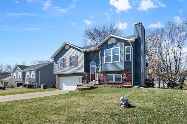 raised ranch featuring a front lawn, brick siding, driveway, and a chimney