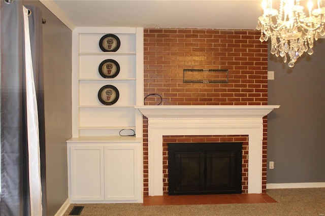 interior details featuring carpet flooring, a fireplace, built in shelves, and a notable chandelier