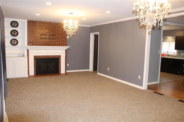 unfurnished living room with a brick fireplace, an inviting chandelier, carpet, and crown molding