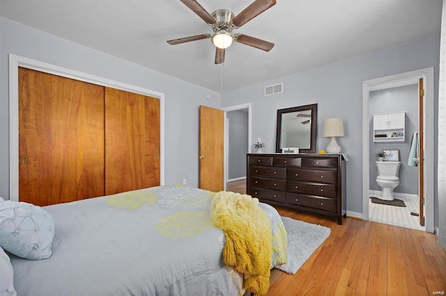 bedroom with light wood-type flooring, ceiling fan, a closet, and connected bathroom