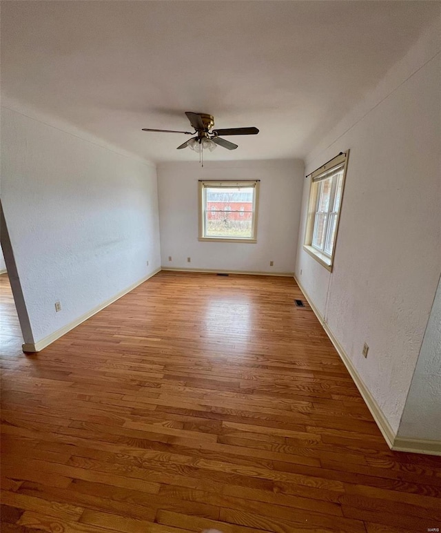 spare room with hardwood / wood-style floors and ceiling fan