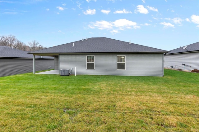 rear view of property featuring a yard and central AC unit