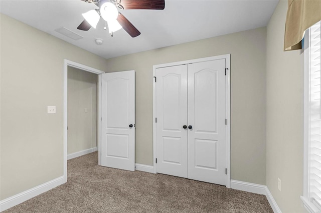 unfurnished bedroom featuring ceiling fan, a closet, and carpet