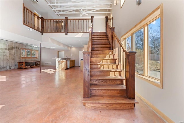 stairway with concrete flooring and a high ceiling